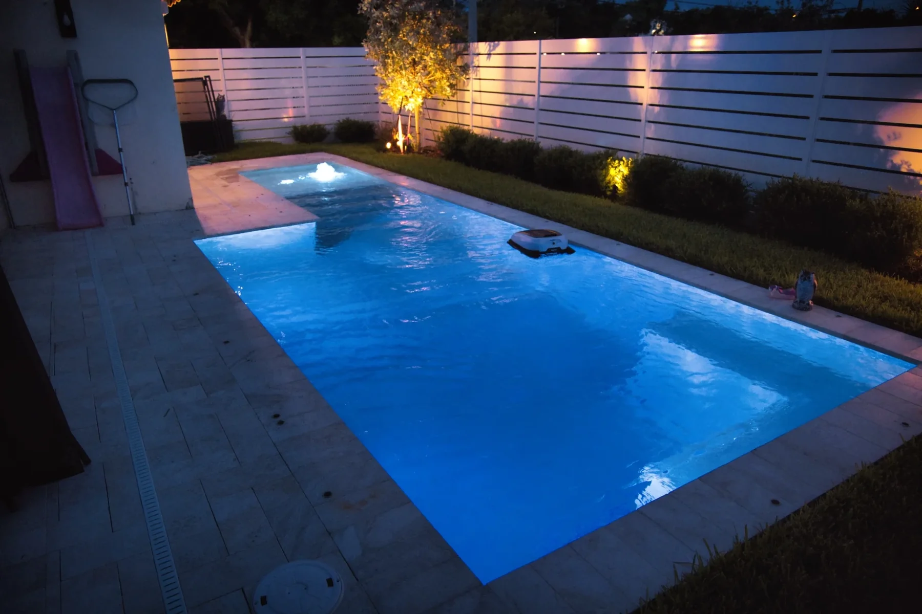 Finished custom pool lit at dusk in South Florida